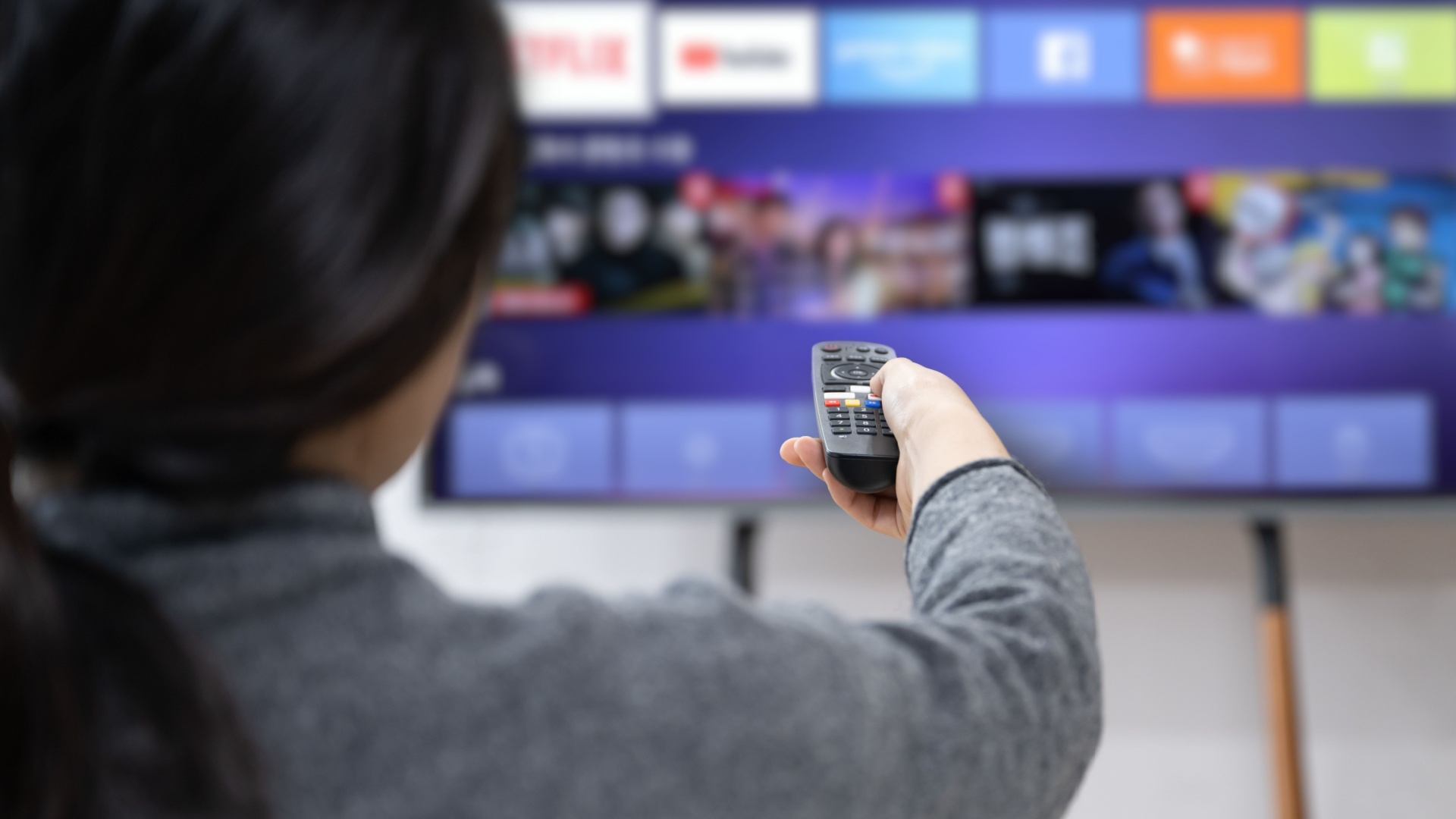 A-woman-experiences-OTT-service-using-a-smart-TV-at-home.jpg